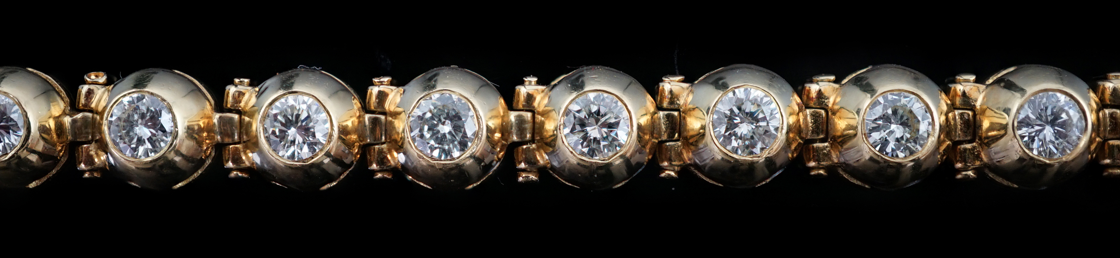 A modern 18ct gold and twenty six round brilliant cut diamond set line bracelet